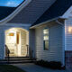 A home's front porch with a lockbox attached to the railing of t